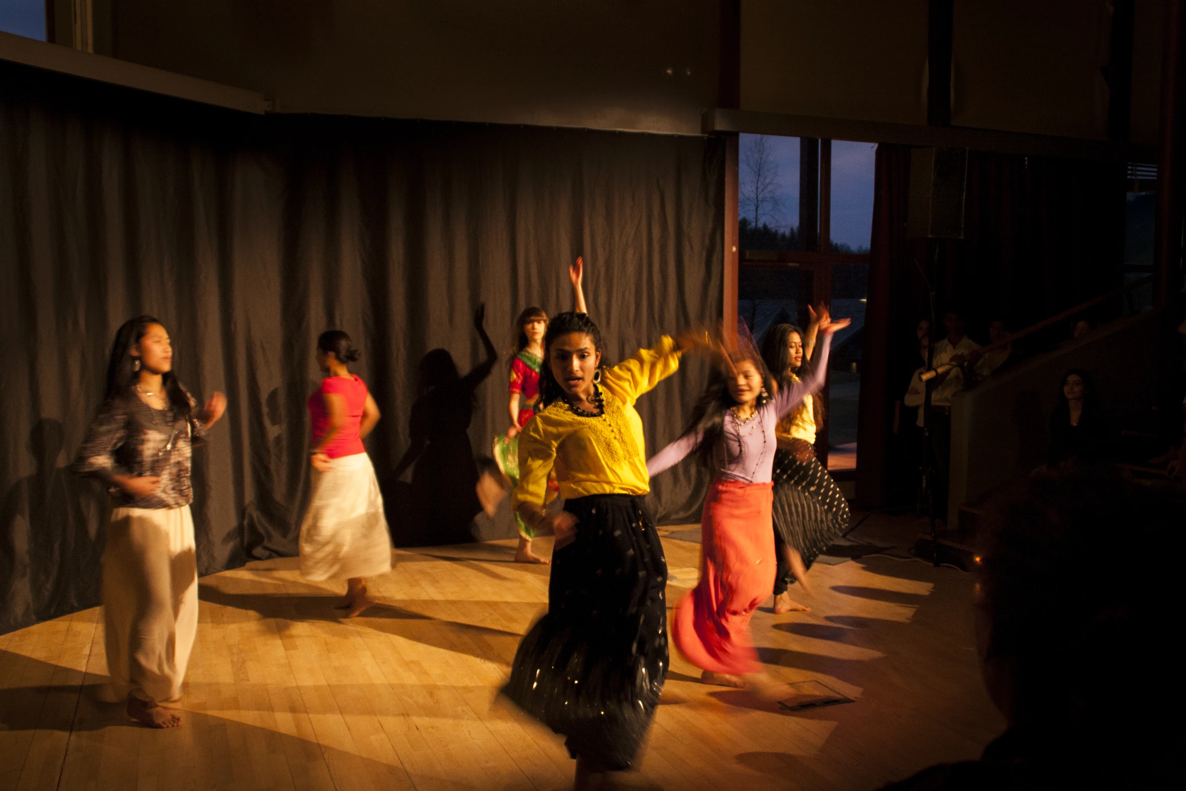 several woman perform in front of an audience on stage