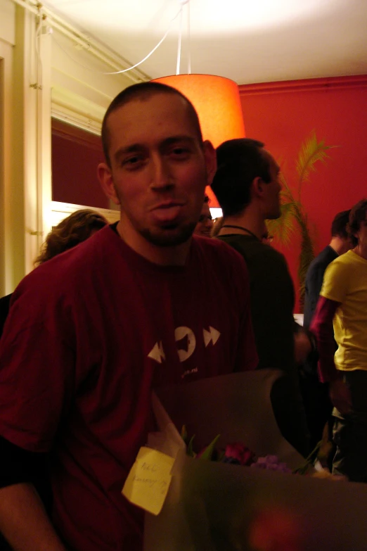 a man holding a brown paper bag standing in front of other people