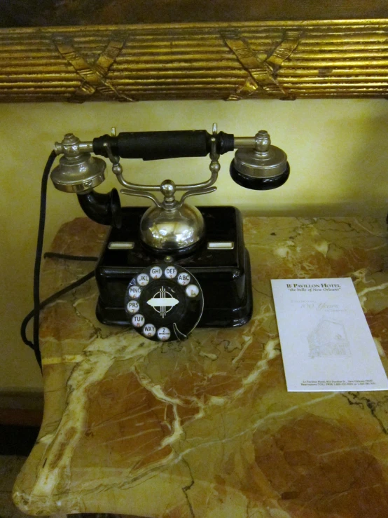 a black antique style telephone is sitting on a table