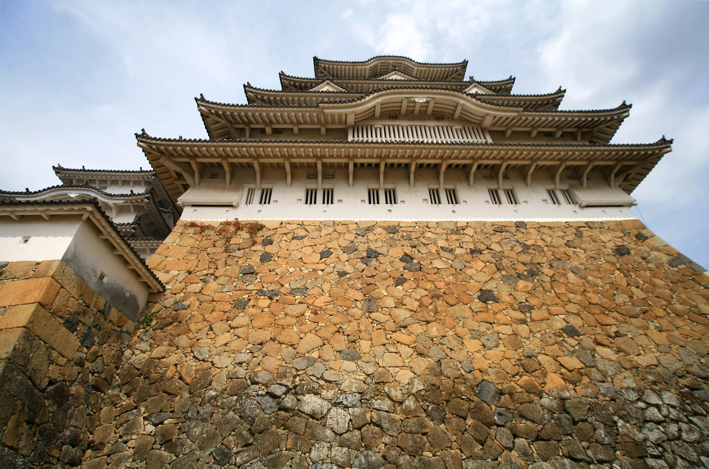 a very large stone wall with a building below