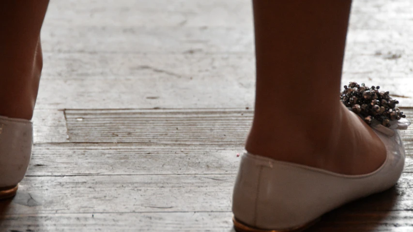 closeup s of female foot wearing low heel slippers on the sidewalk