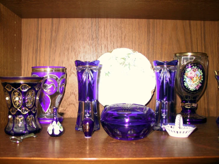 a shelf with many purple and white vases on it
