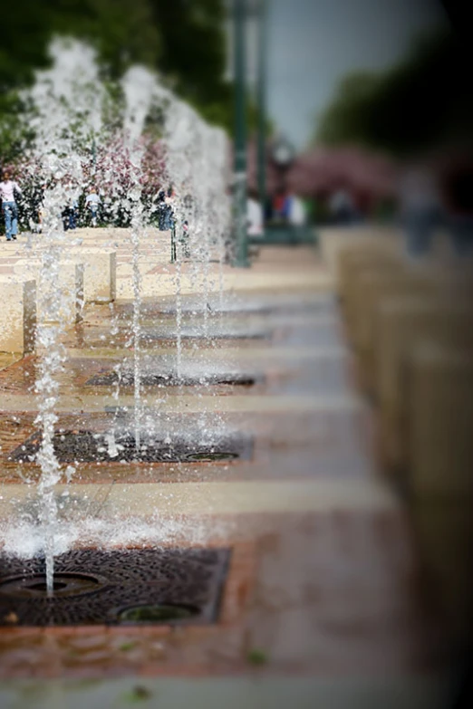 several fountains spewing out water into a street