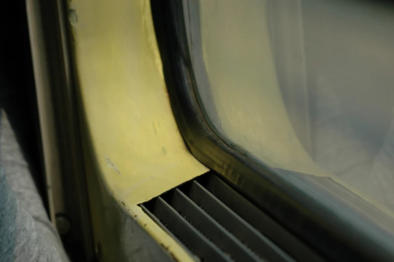 a yellow train seat with some black bars