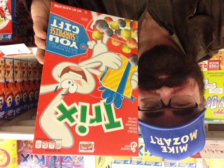 a man with glasses and a mustache standing next to a cereal box