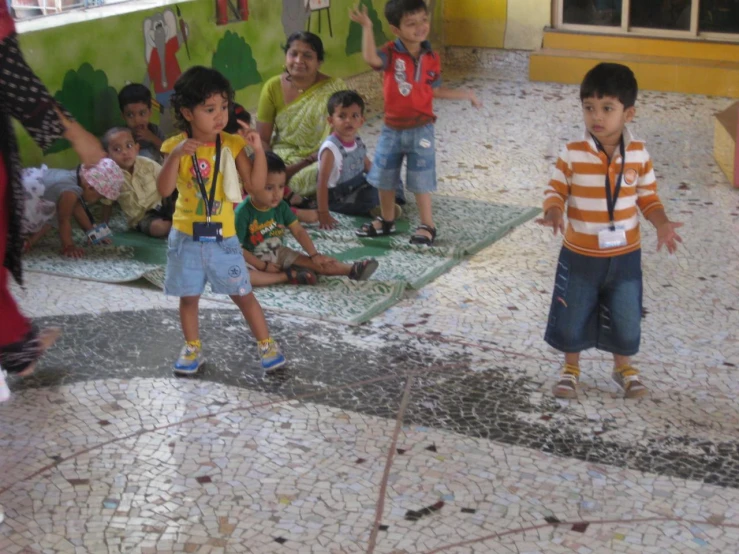 many children stand together in the room playing