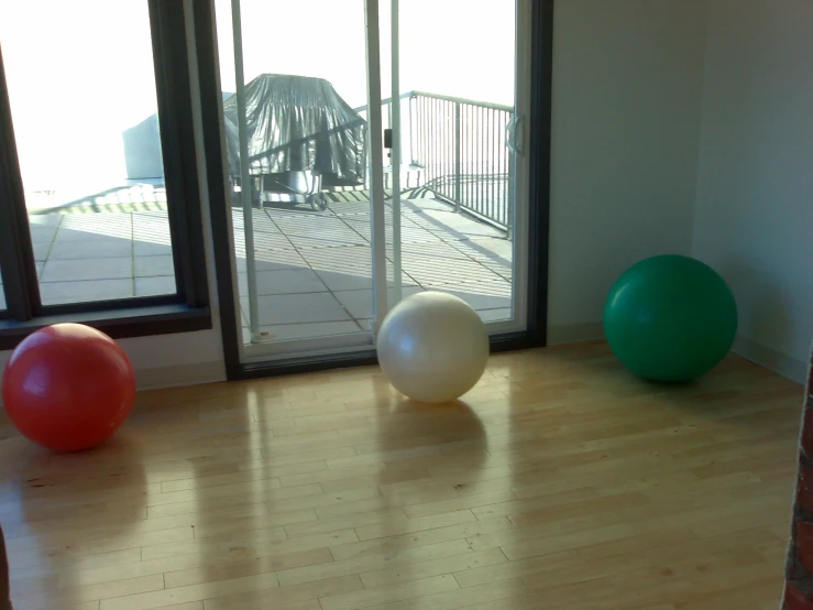 three exercise balls, one on the ground in front of a doorway