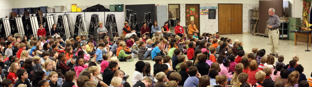 a crowd of people inside of a gym next to doors