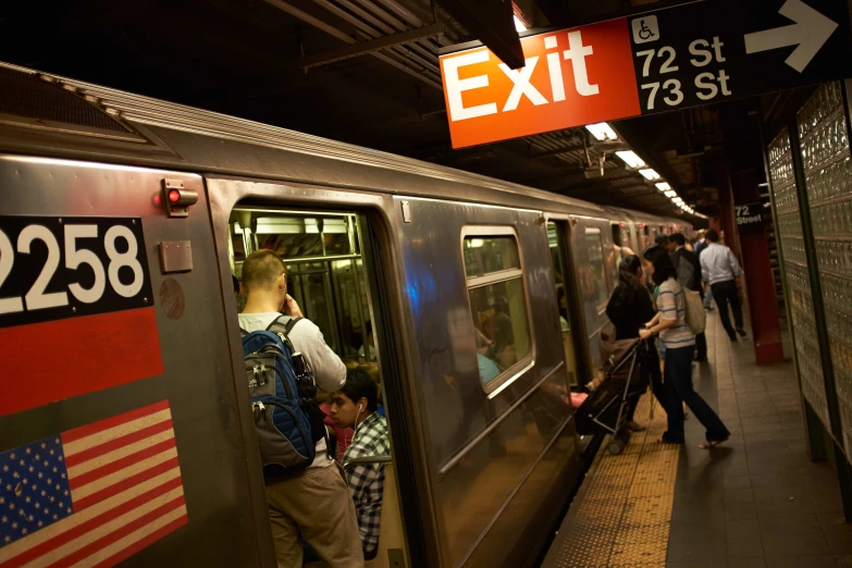 people in the subway boarding and exiting an exit