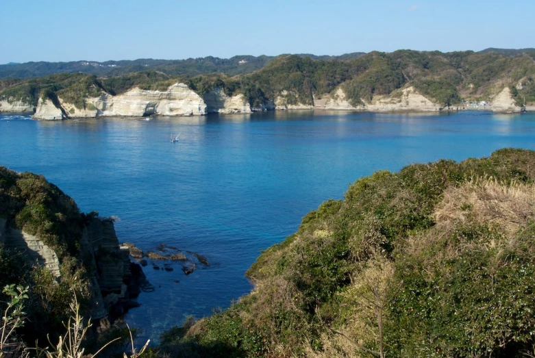 blue ocean with white cliffs on the horizon