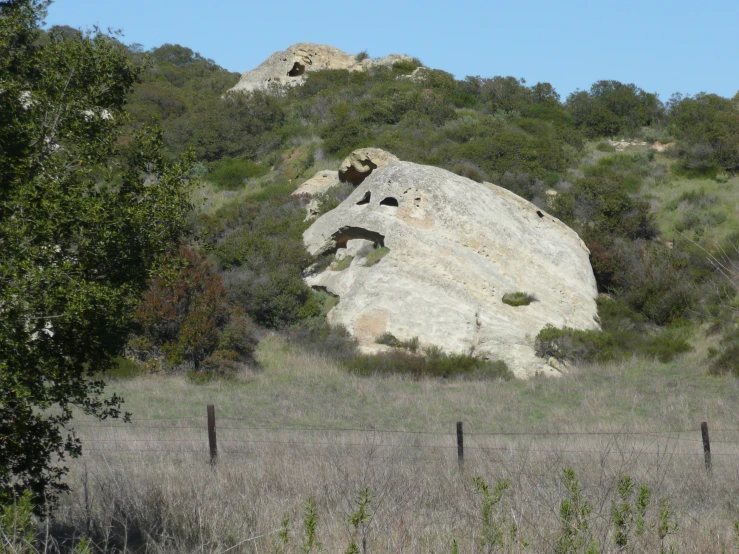 a huge rock sticking out of the side of a hill