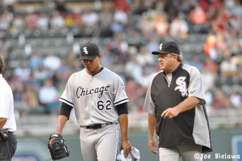 one baseball player is trying to talk with the other player on the field