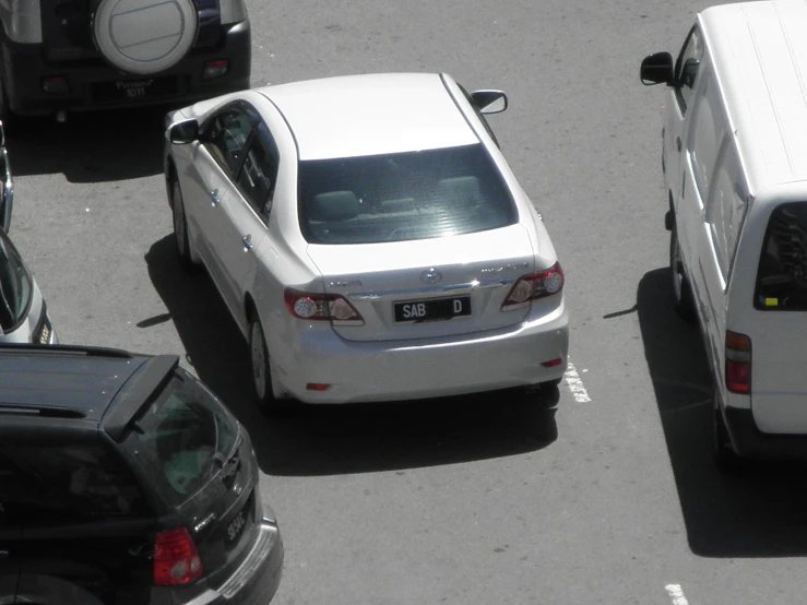 cars are driving down the street near several trucks