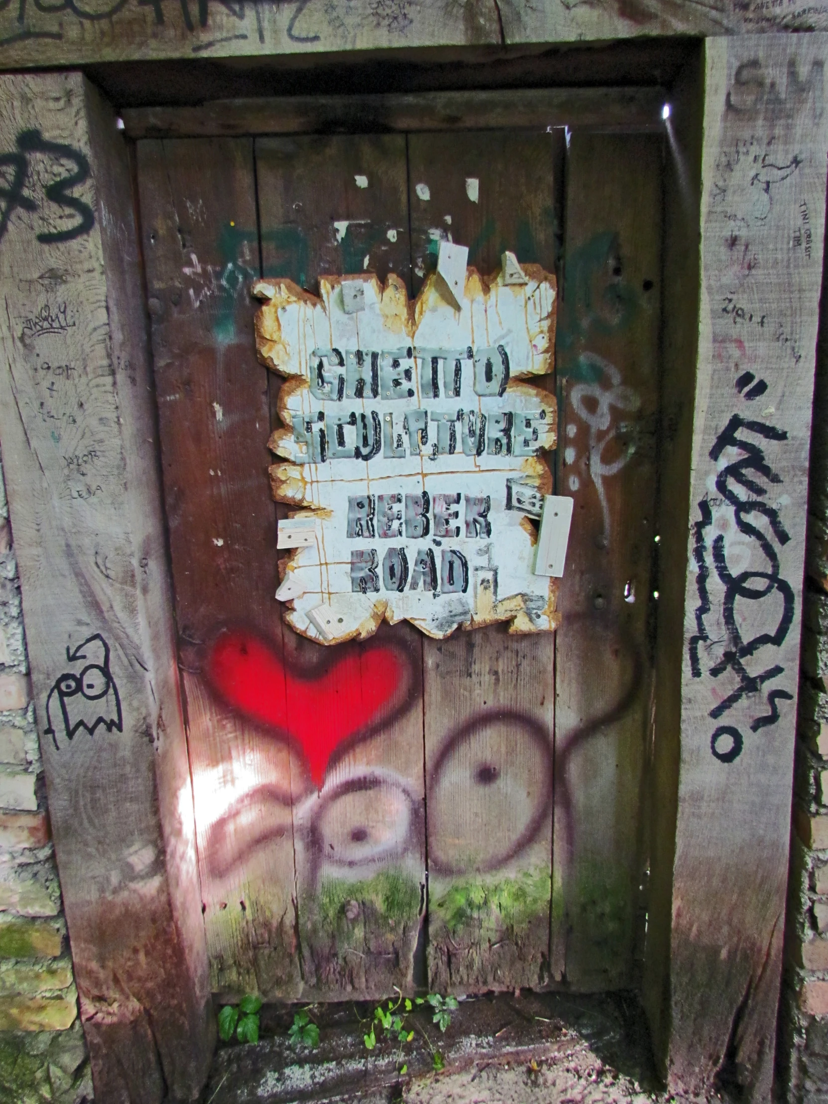 a rusty door with graffiti painted on it