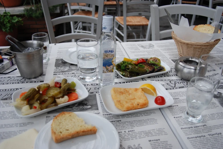 a table with plates and bread, fruit and salad