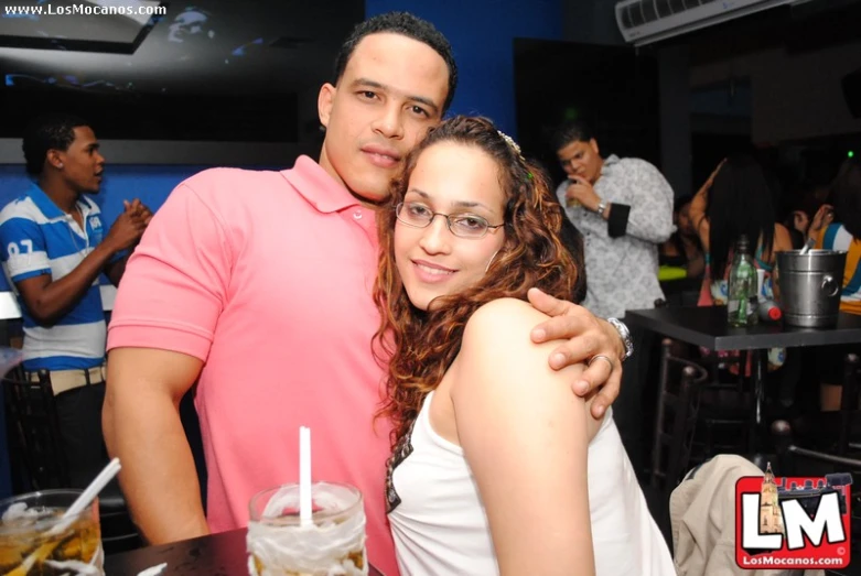 a man and woman posing in front of a table with drinks