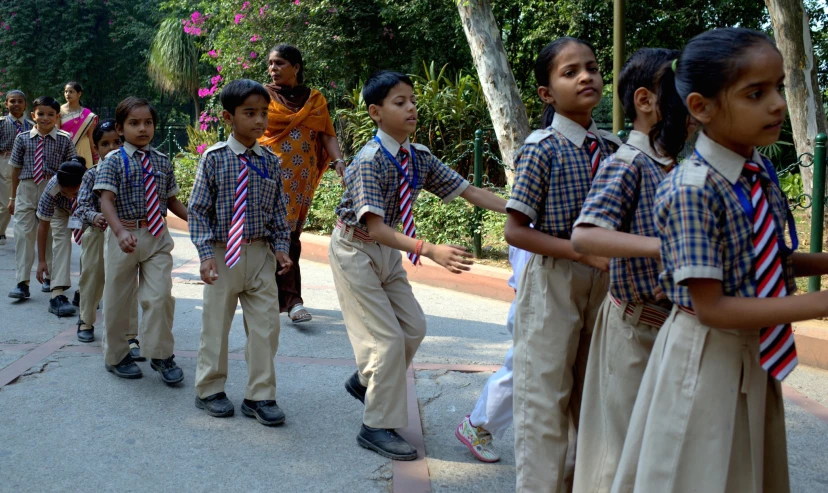 a line of school children wearing ties outside