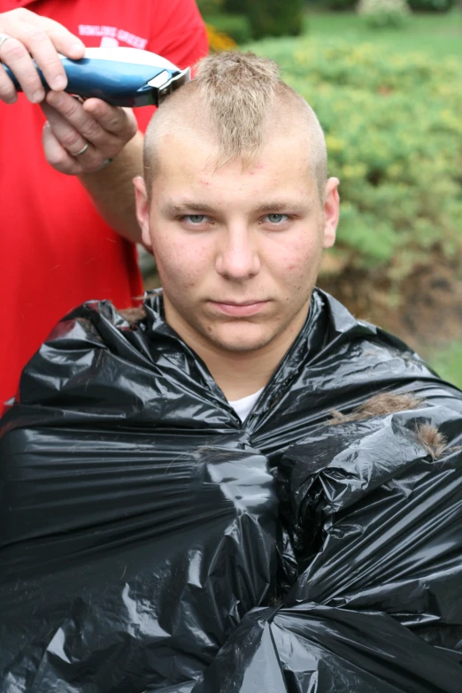 the man is getting his hair cut by the owner