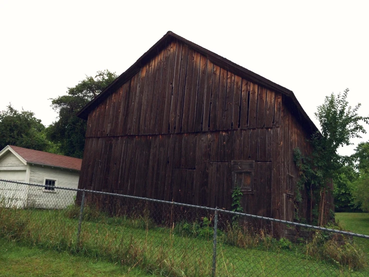 a barn sits next to an outhouse on a hill