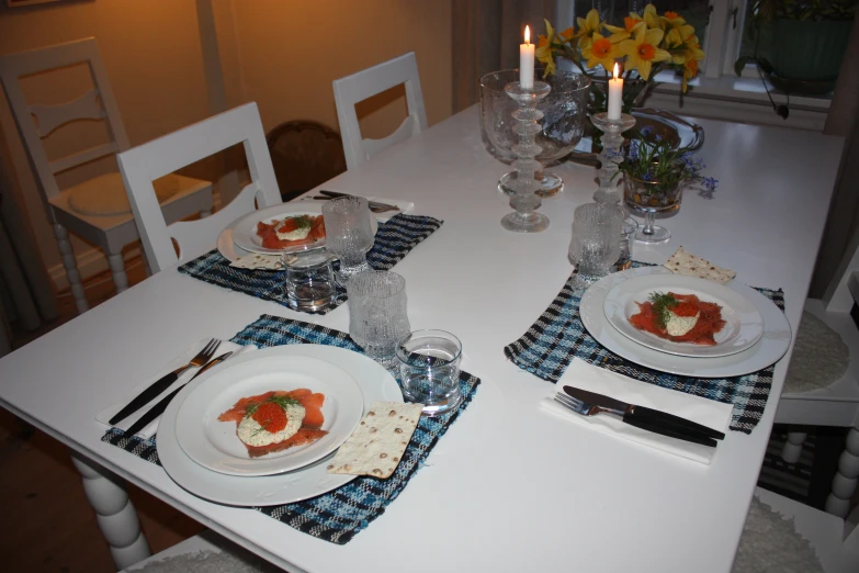 the table set up for dinner has dishes of food and silverware