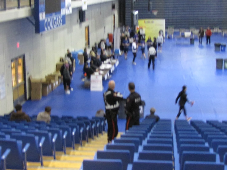 several people walk through the middle of an auditorium