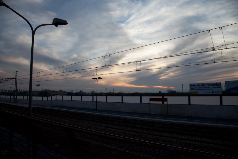 an empty track in front of a sky with clouds