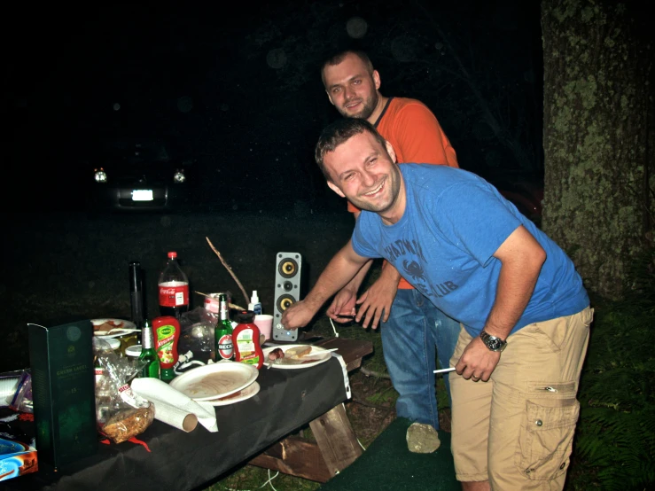 two men who are standing by a table