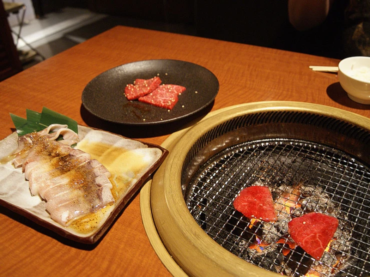 various types of food being prepared on an outside grill