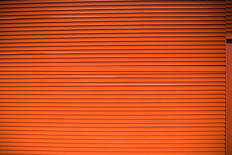 the image of the corner of a building, red walls and window shutters