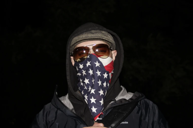 a person in sunglasses and an american flag bandana