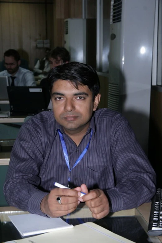 a man sitting at his desk using a phone