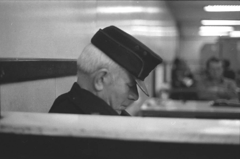 a man wearing a hat and sitting in a booth