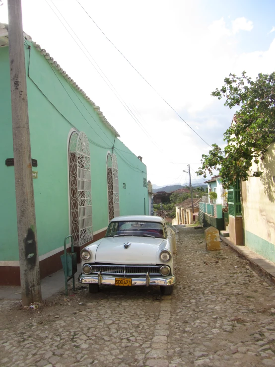 a car parked in the road behind an arch