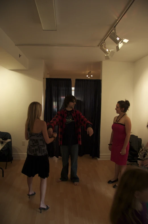 three women and one man standing in a room