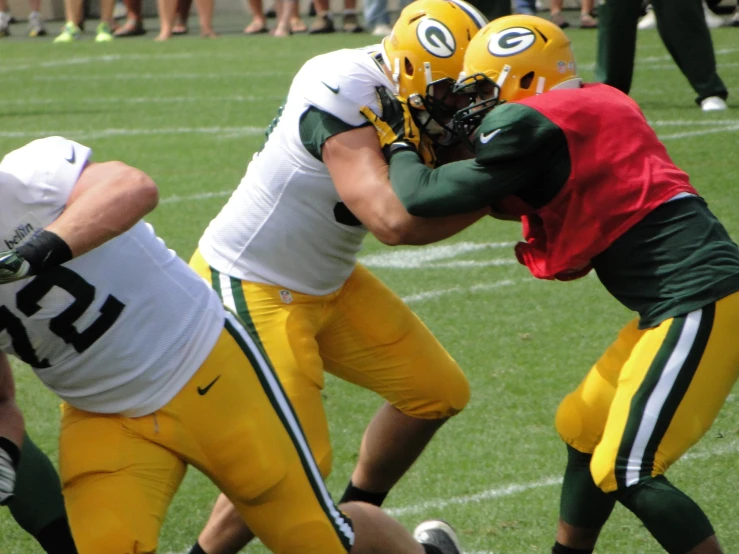 two green and yellow football players and one player