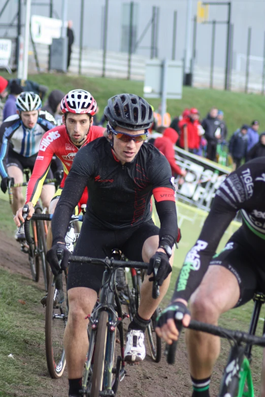 cyclists ride down the dirt path in front of other cyclist