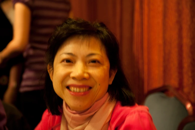 a woman in a pink sweater smiling and posing for the camera