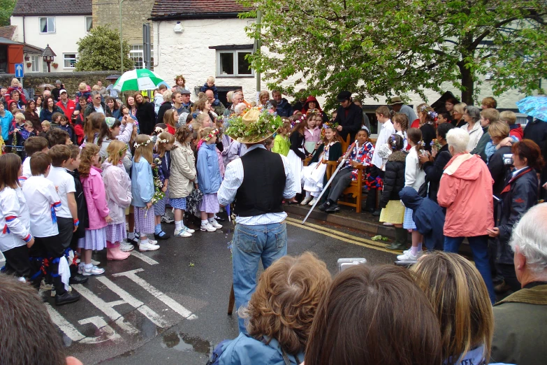 a crowd gathered in front of houses at a parade