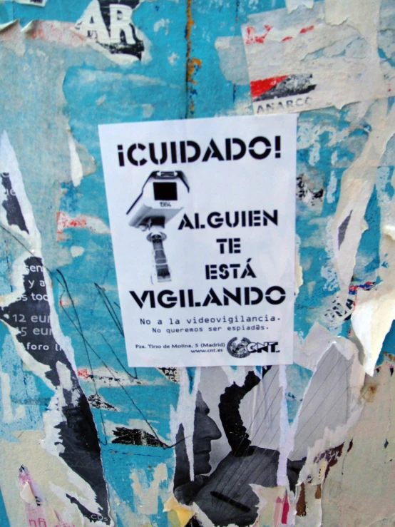 a poster on a wall in spanish is taped