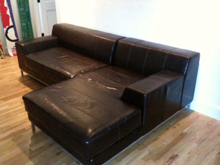 two leather couches and one ottoman in an apartment