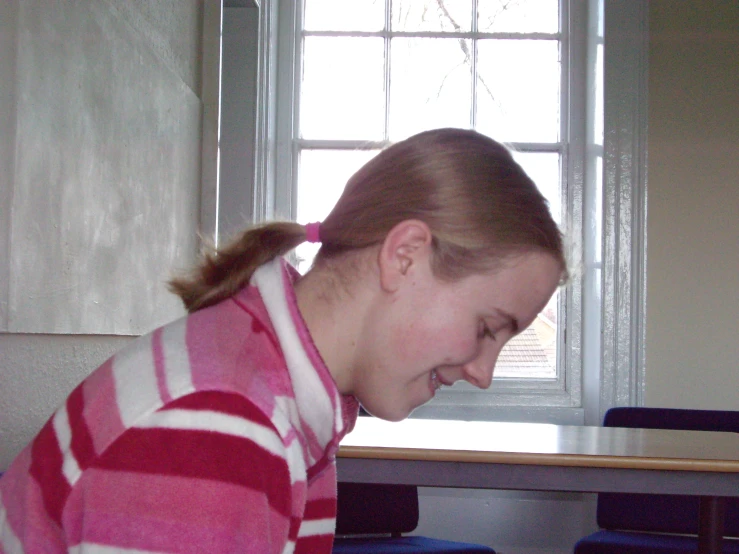 a young woman laughing next to a wooden table