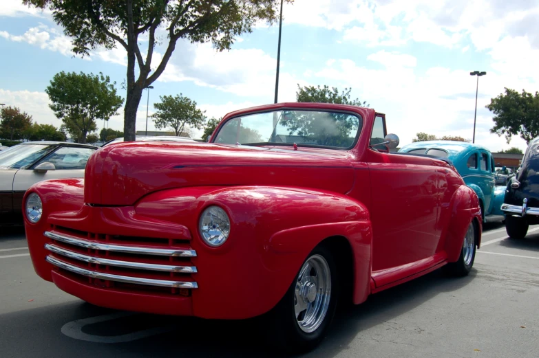 a red truck in parking lot with other cars