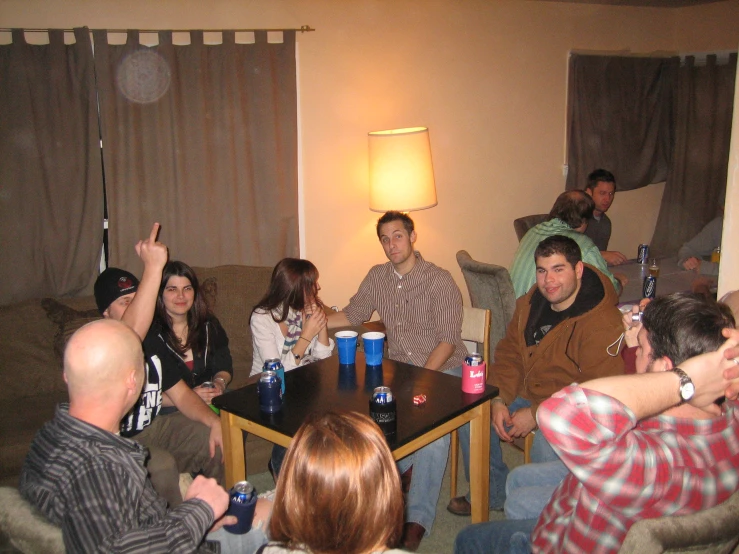 a group of friends talking and drinking in a living room