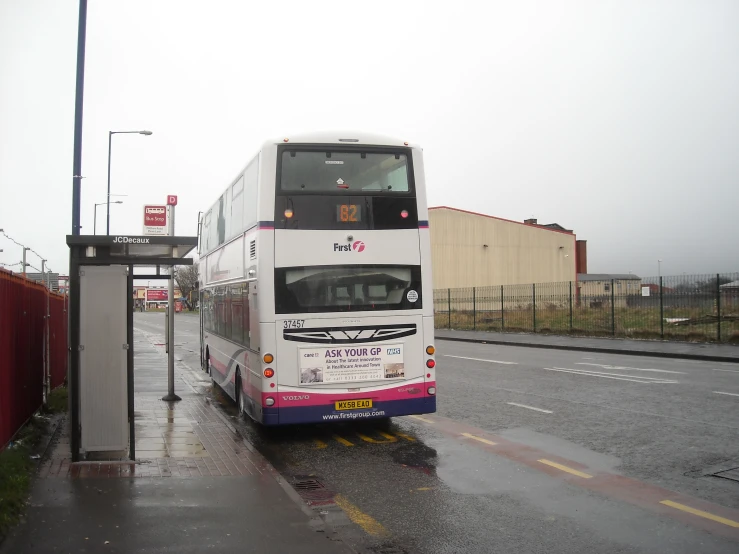 a double deck bus traveling down a wet road