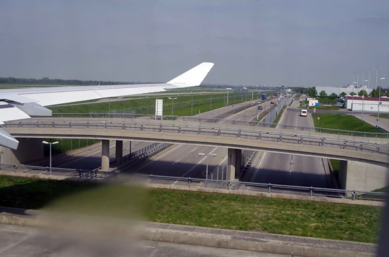 an airport showing a freeway and cars under an overhead bridge