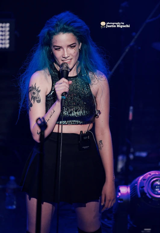 the girl with green hair is singing into a microphone