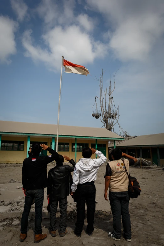 three people are holding a flag near a building