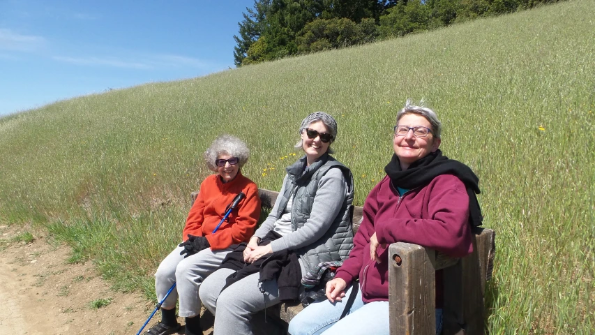 two women are sitting down on a bench