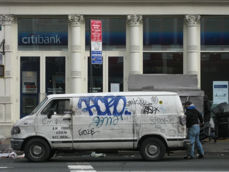 some people near a white van with writing on it