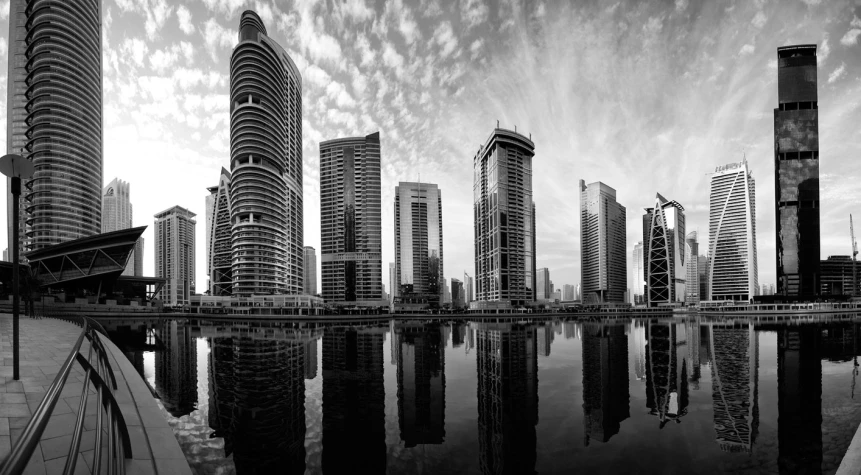 several skyscrs reflecting in the water at dusk